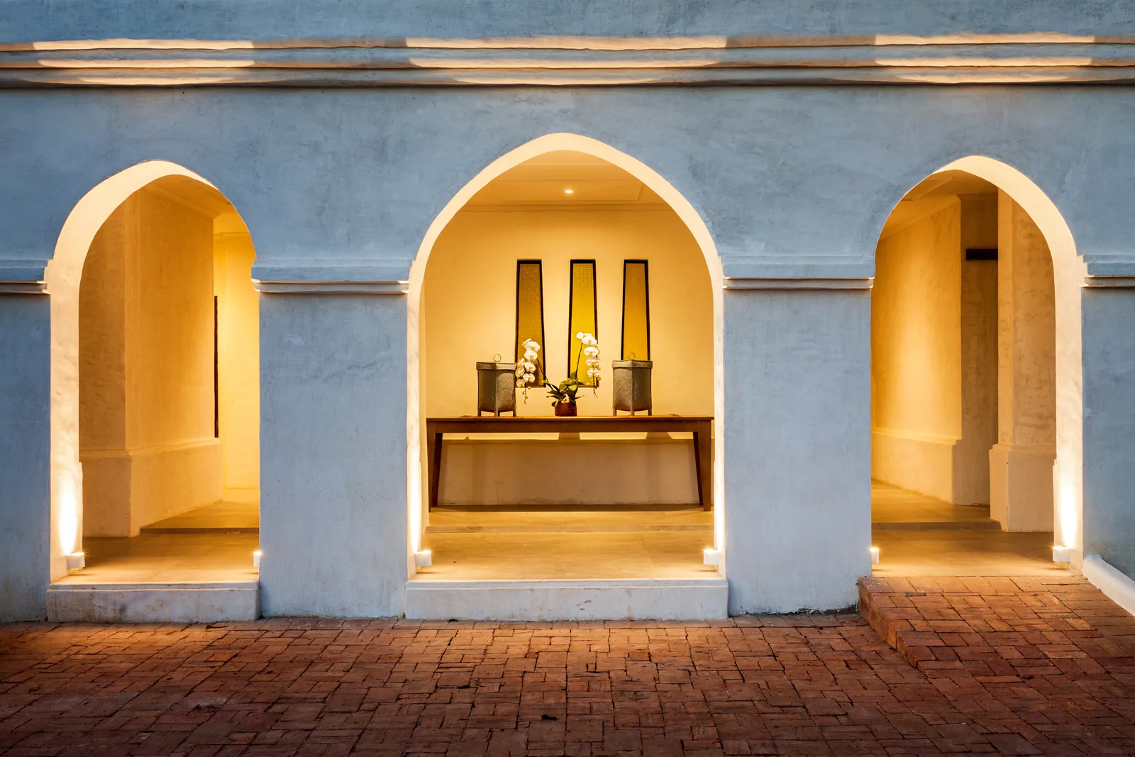 Illuminated Sukhothai-style entrance arches at night