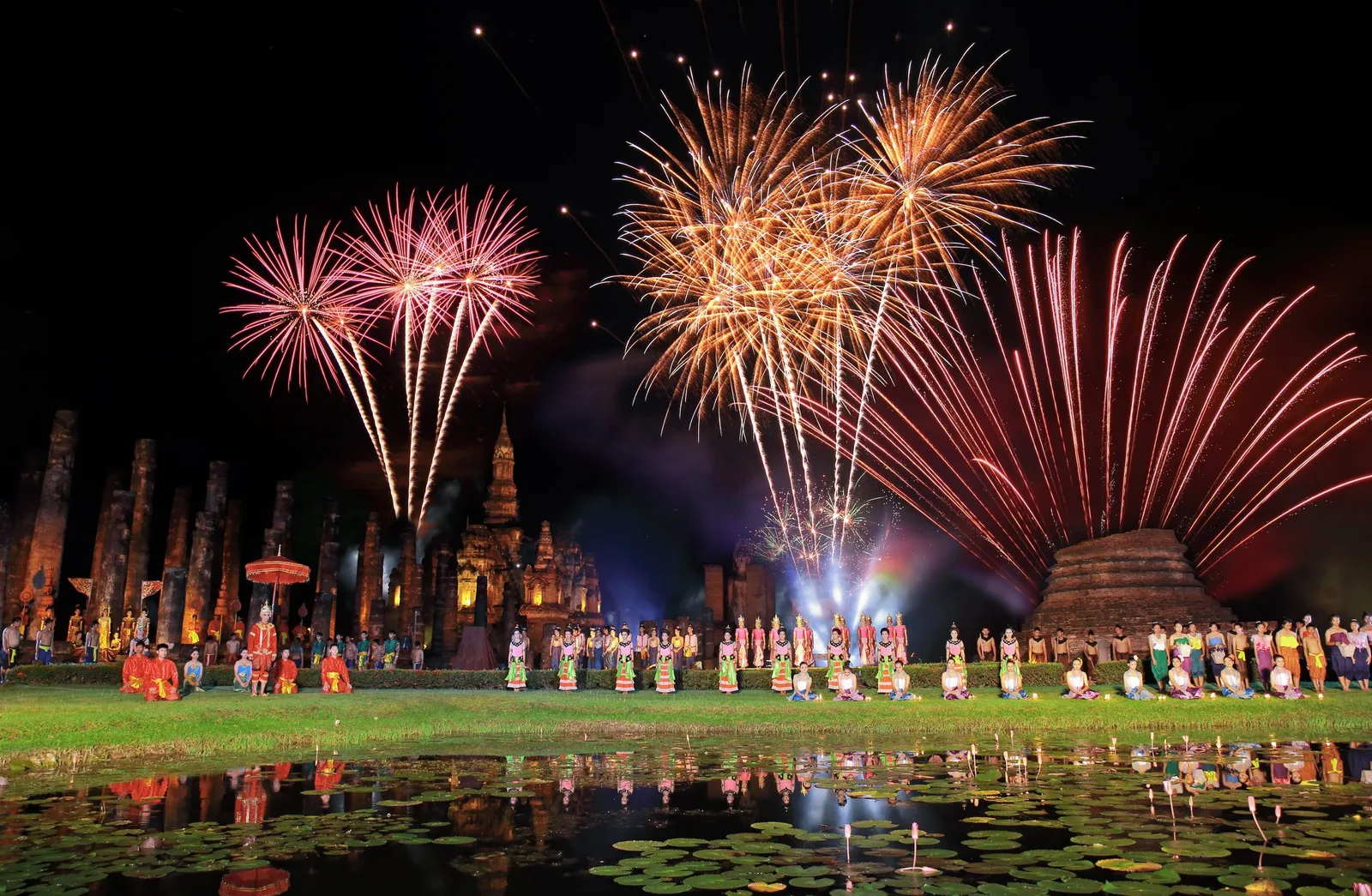 Illuminated krathong floating on the ancient moat of Sukhothai during the Loy Krathong festival at night