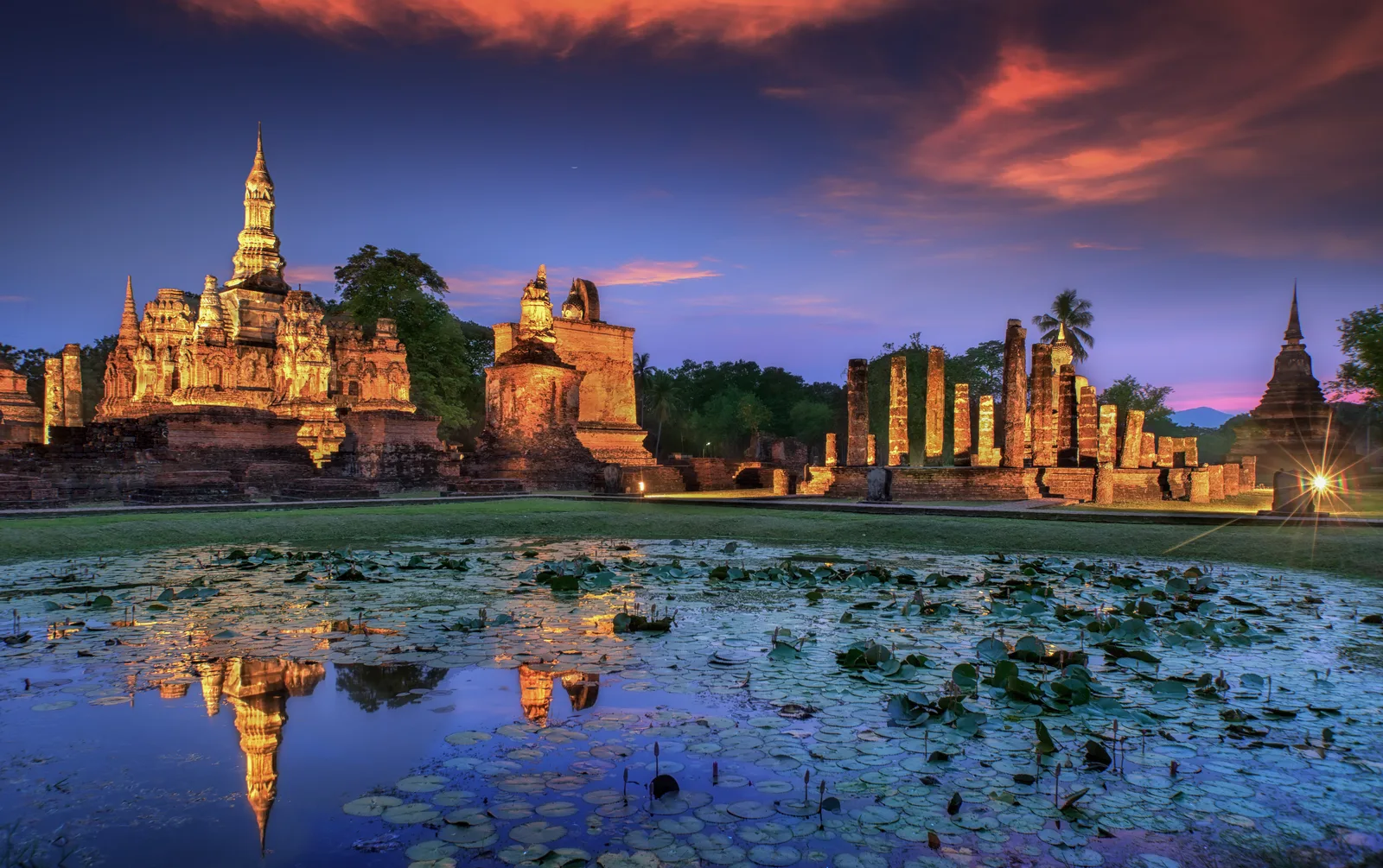 Morning mist drifting across the lotus moat surrounding Wat Mahathat