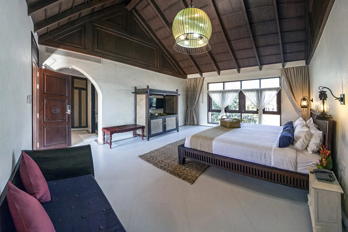 Superior Room — king bed with warm rattan and bamboo tones, garden beyond